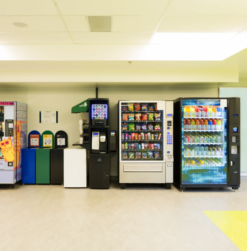 Row of vending machines and bins indoors
